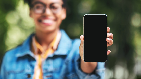 Unrecognizable Black Woman Showing Cellphone Empty Screen Recommending Application Standing Outdside. Shallow Depth, Mockup, Panorama