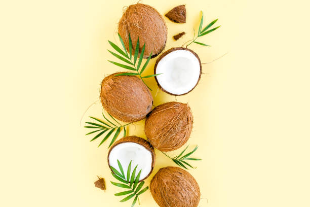istock Pattern with coconuts and tropical palm leaves on yellow background. Tropical abstract background. Flat lay, top view 1272986722
