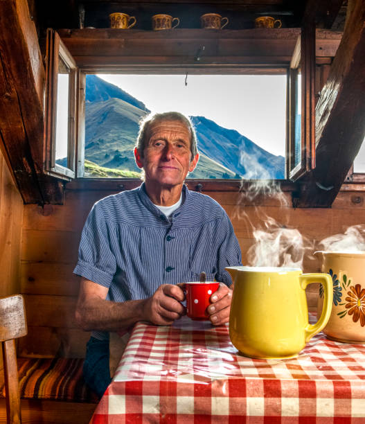 farmer drinking coffee in farmhouse, switzerland - home interior cabin shack european alps imagens e fotografias de stock