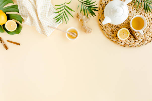 istock Herbal tea with mint, ginger, lemon, honey and other herbs on yellow background. Flat lay, top view 1272988102