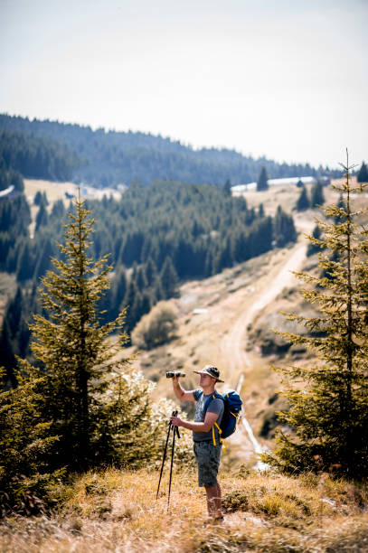 istock Hiker watching landscape and holding binoculars 1272991653