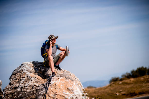 istock Hiker watching landscape and using phone 1272992294
