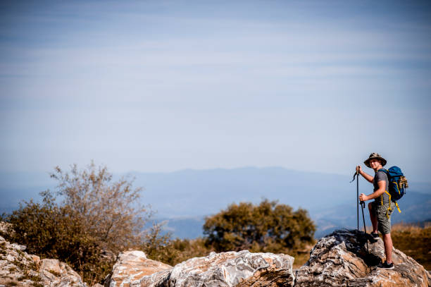 istock Man taking a break from his hike on a sunny day for breathtaking views 1272992759