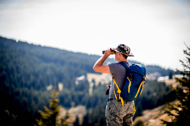 istock Hiker watching landscape and holding binoculars 1272993658