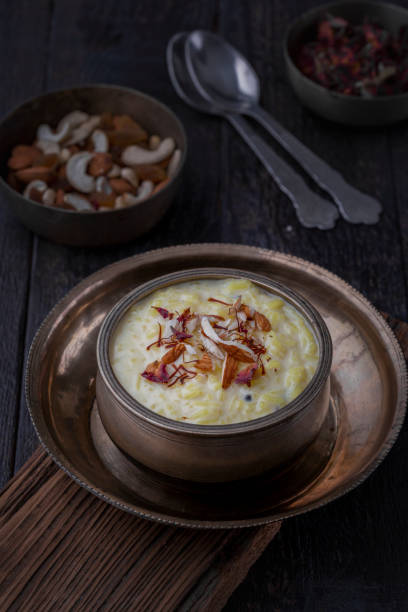 Kheer or Payasam is a rice pudding served in traditional utensils Kheer or Payasam is a type of rice pudding from the Indian subcontinent, made by boiling milk and sugar and is flavoured with dry fruits and nuts, served in decorative plate. eid ul fitr photos stock pictures, royalty-free photos & images