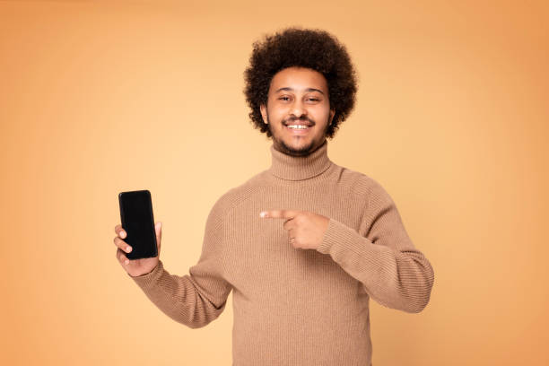 istock Smiling afro guy showing mobile phone. 1273000207