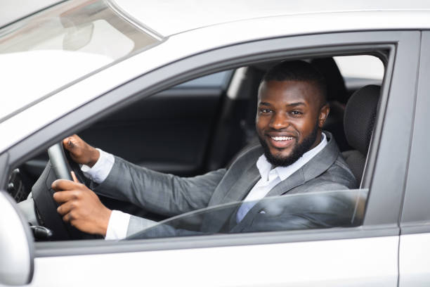 istock Handsome black businessman smiling while driving car 1273000294