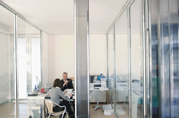 istock Two businesspeople sitting in office having meeting elevated view 1273000396