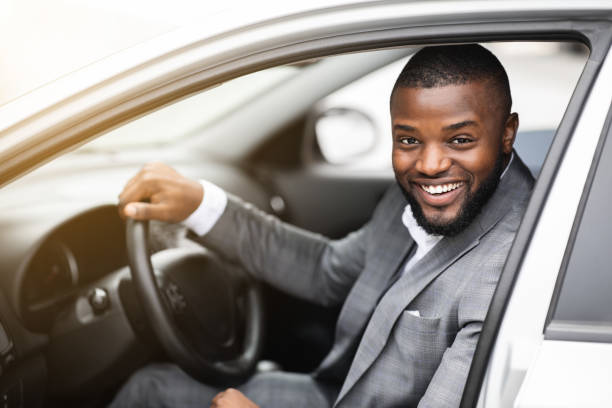 istock Cheerful successful black businessman looking through car window 1273001378