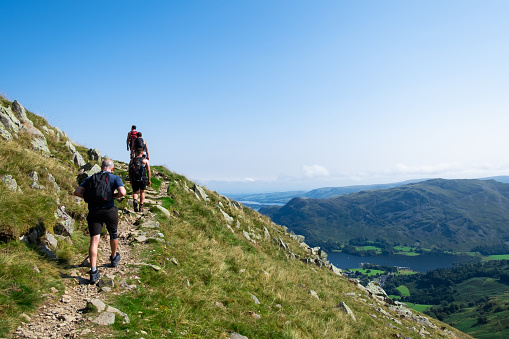 Male hiker exploring the Great Langdale valley in the Lake District, famous for its glacial ribbon lakes and rugged mountains. Popular vacation destination in Cumbria, North West England.