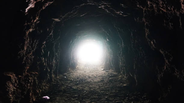 Light at the end of a long cave and children