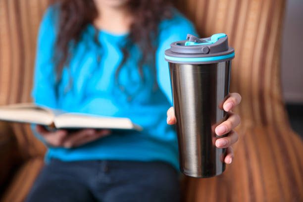 istock woman hand thermos and book 1273004067