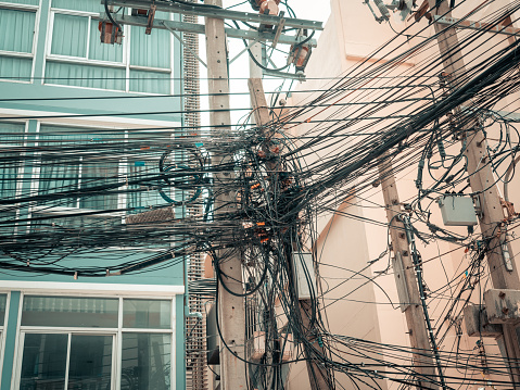 Messy wires attached to the electric pole, the chaos of cables and wires on an electric pole in Bangkok, Thailand. Tangle wire.