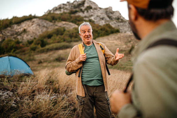 elderly father with adult son on a picnic - camping tent offspring 60s imagens e fotografias de stock