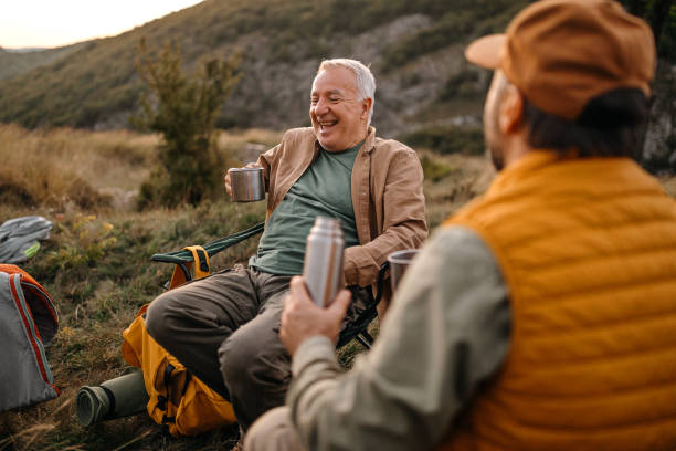 istock Son with father serving coffee while relaxing on a picnic 1273010170