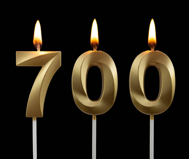 istock Birthday golden candle on black background, number 700 1273010552