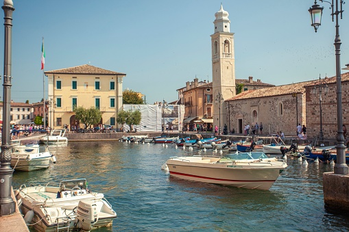 Lazise, Italy 16 September 2020:  Dogana Veneta and Porticciolo in Lazise, in Italy with colored boats