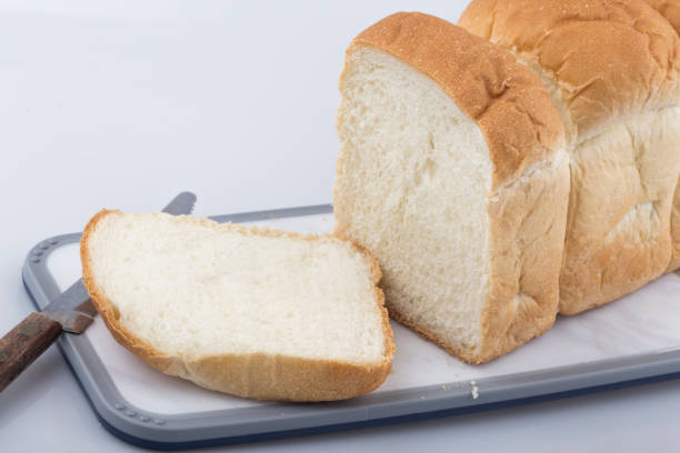istock Well sliced loaf of bread on a cutting board with knife. 1273014358