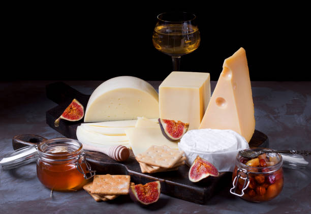 cheese board with brie, maasdam, gouda and goat cheese, figs, honey and jam - italian cuisine wine food pasta imagens e fotografias de stock