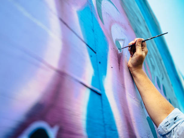 istock Hand of Female mural artist at work 1273015975