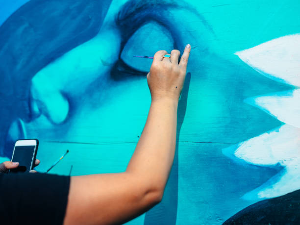 istock Hand of Female mural artist at work 1273016081