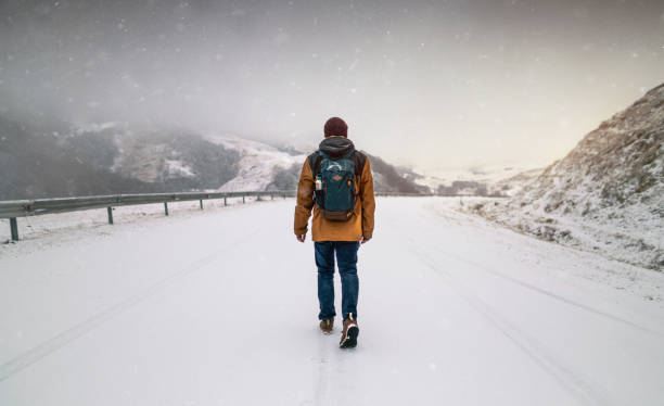 istock Walking the snowy road in the mountains 1273016138