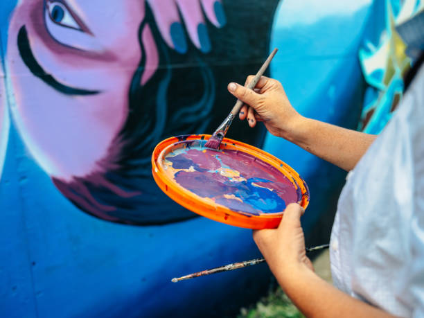 istock Hand of Female mural artist at work 1273017001