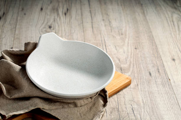 istock Template. White and empty deep plate on wooden table and earth-colored napkin 1273017642