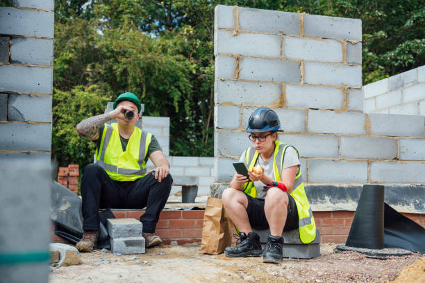 Enjoying Our Break A shot of a male and female construction worker sitting having a break on a building site. construction lunch break stock pictures, royalty-free photos & images