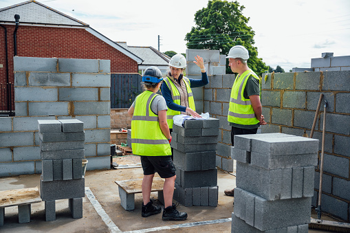 A shot of a female site manager having an on-site meeting with female and male construction workers on a building site.