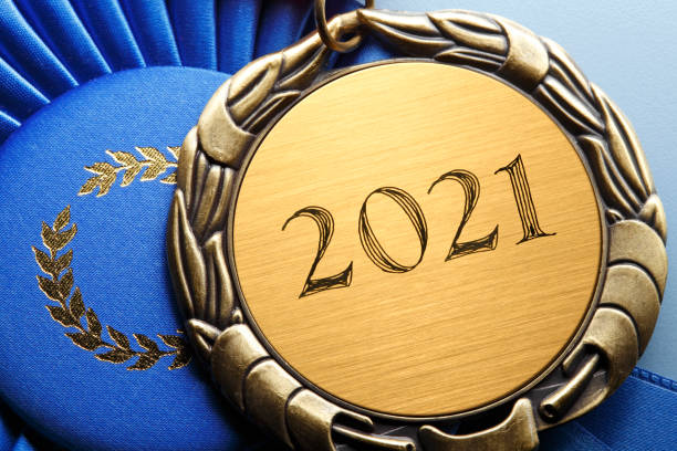 青いリボンに休む「2021」で刻まれたメダルのクローズアップ - gold medal medal ribbon trophy ストックフォトと画像