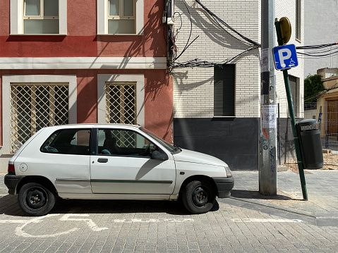 Valencia, Spain - September 12, 2020: White Renault model Clio RN parked in handicapped reserved place in residential district. It is produced by the French manufacturer since 1990