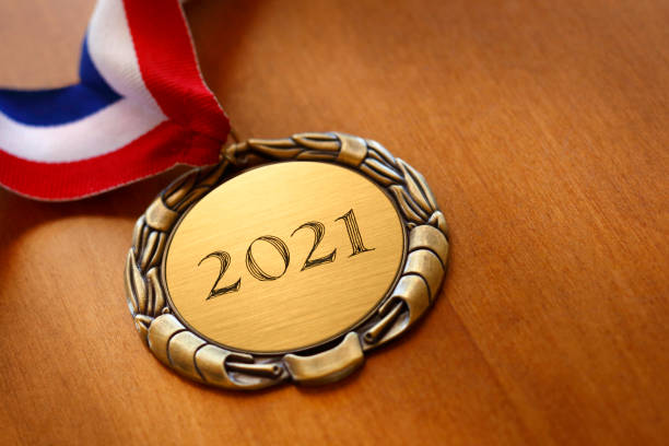 istock Gold Medal Engraved With 2021 On Wood Surface 1273026216