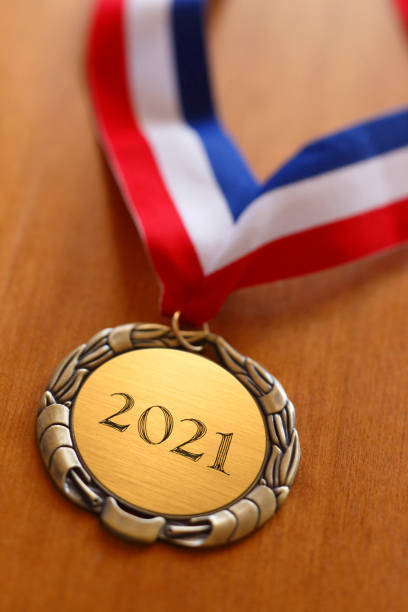 istock Gold Medal Engraved With 2021 On Wood Surface 1273028991