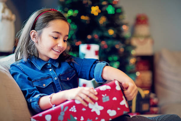 istock Happy girl is opening her Christmas gift 1273029779