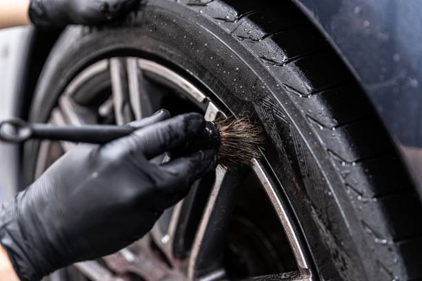 istock Car detailing studio worker cleaning car wheel with special brush. 1273032558