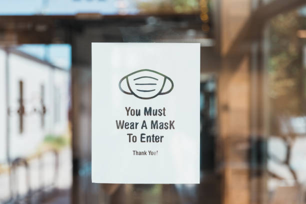 Black and while sign mandating masks on window or door