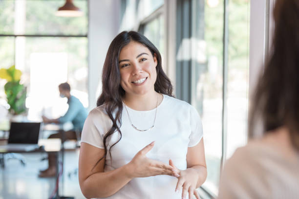 istock Young adult woman smiles and gestures while talking 1273039844