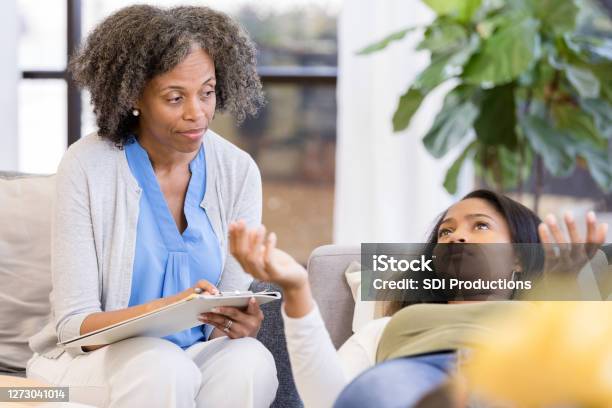 Teen Girl Gestures From Lying Down Position On Therapists Couch Stock Photo - Download Image Now