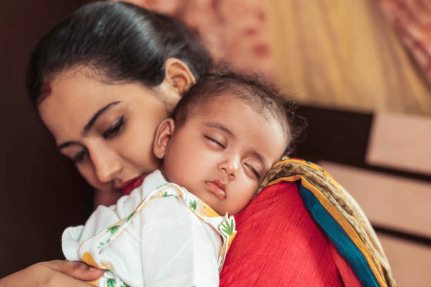 istock Mother holding her sleeping baby on shoulder. 1273051788