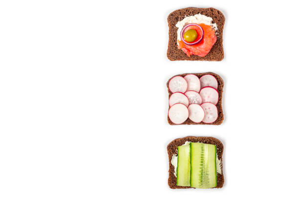 istock Appetizer, open sandwich with different toppings: salmon and vegetables on white background. Traditional Italian or Scandinavian cuisine. Healthy eating. Flat lay, copy space for text 1273056246