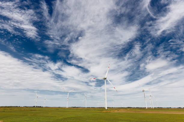 German wind turbines in nature on cornfields and meadows during the day photographed under impressive skies. In High resolution with copy space