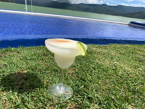 A Mexican Margarita frozen in the grass with the swimming pool behind. Valle de Bravo
