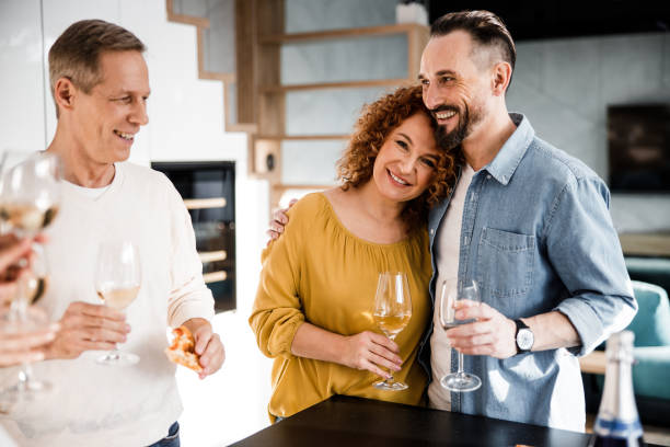 istock Smiling couple is posing at camera and holding wine 1273129997