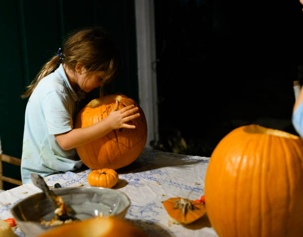istock Child carves a Halloween pumpkin 1273133073