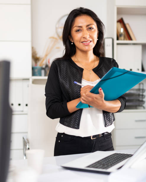 istock Successful Hispanic business woman writing down tasks 1273134621