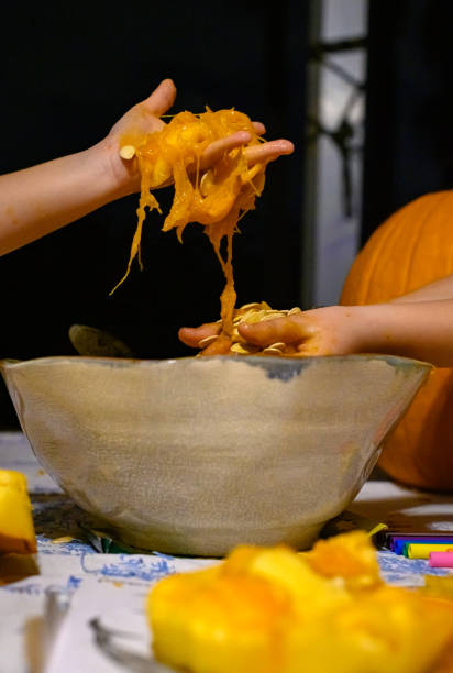 istock Messy hands covered in pumpkin seeds and guts 1273137926