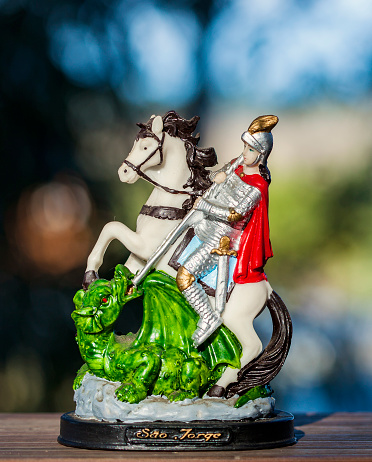 Stuatue of Saint George and the Dragon with natural light and green background. Copy Space