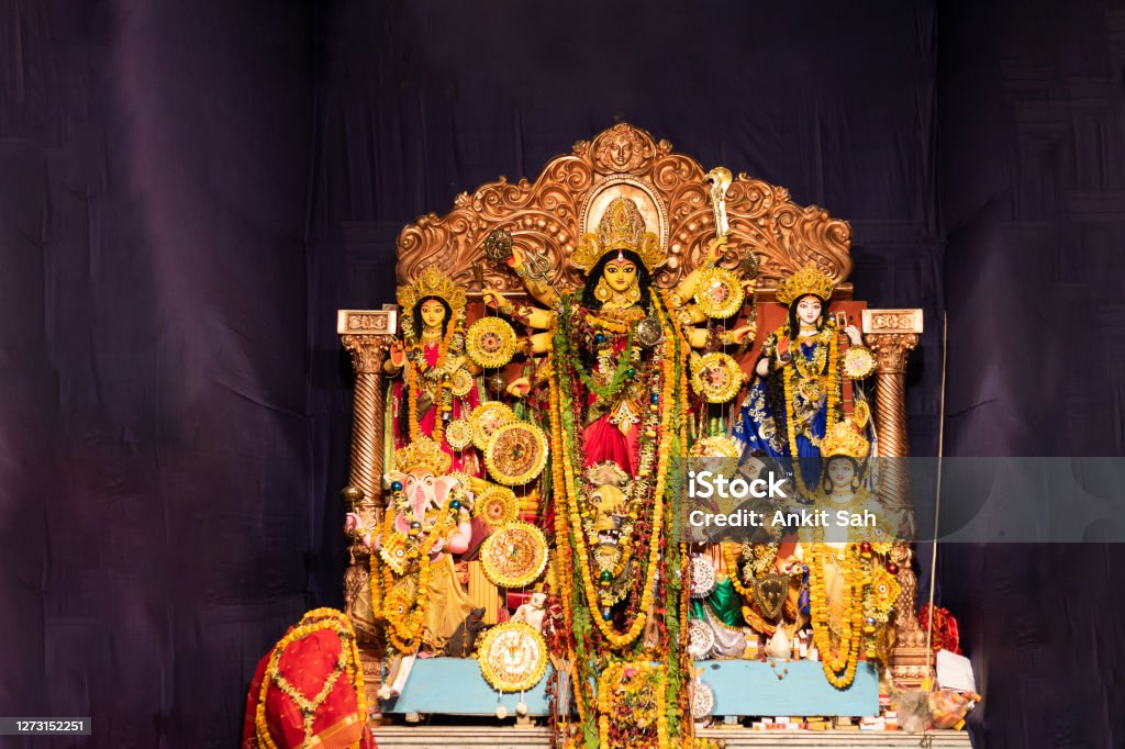 Hindu Goddess Durga during Durga Puja Celebrations. An Idol of Hindu goddess Durga placed in a temporary shed made out of canvas and bamboo, and is decorated with colorful cloths called as Pandal for worship, The deity made out of clay is adorned with decorative work. Durga Puja ,also called Durgotsava  is an annual Hindu festival originating in the Indian subcontinent, mainly in West Bengal and Kolkata which reveres and pays homage to the Hindu goddess, Durga. Durga Stock Photo