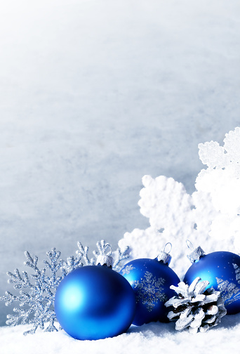 Christmas balls and snowflake on white and blue winter background.